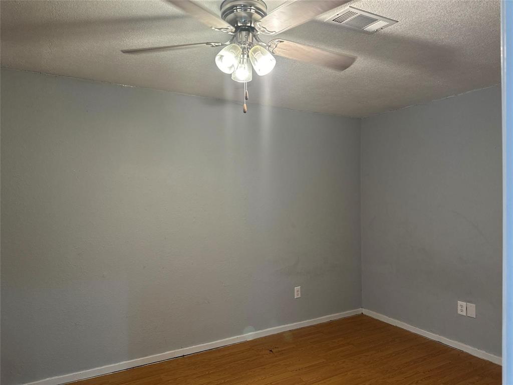 4601 Elm Ridge Lane Garland, TX 75044 - Photo 7 of 21 Wood-finish flooring with light gray walls, white baseboards, and a ceiling fan with integrated lighting