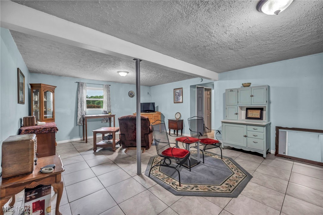 4743 County Line Road Newton Falls, OH 44444 - Photo 27 of 36 Living room with a textured ceiling, light tile patterned floors, and an office area