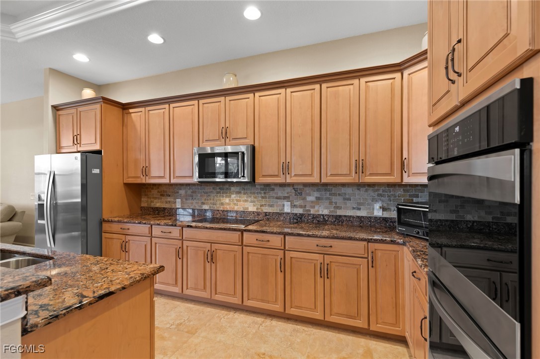 6057 Calusa Rdg Trail Bokeelia, FL 33922 - Photo 8 of 45 a kitchen with granite countertop stainless steel appliances a stove sink and microwave