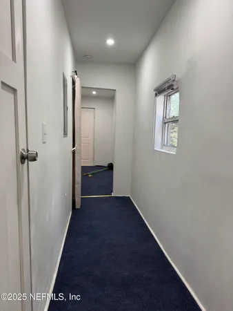 a view of a hallway with wooden floor and closet