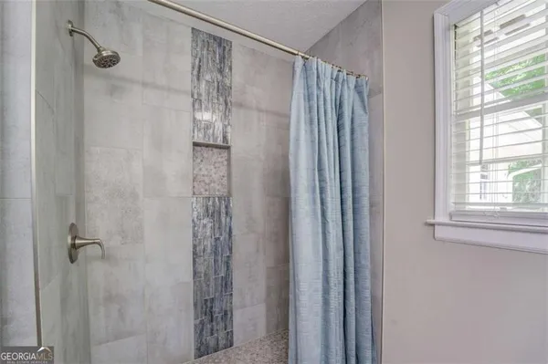 a bathroom with a shower and a mirror