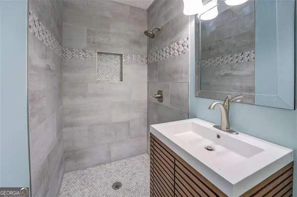 a bathroom with a sink a shower and a mirror