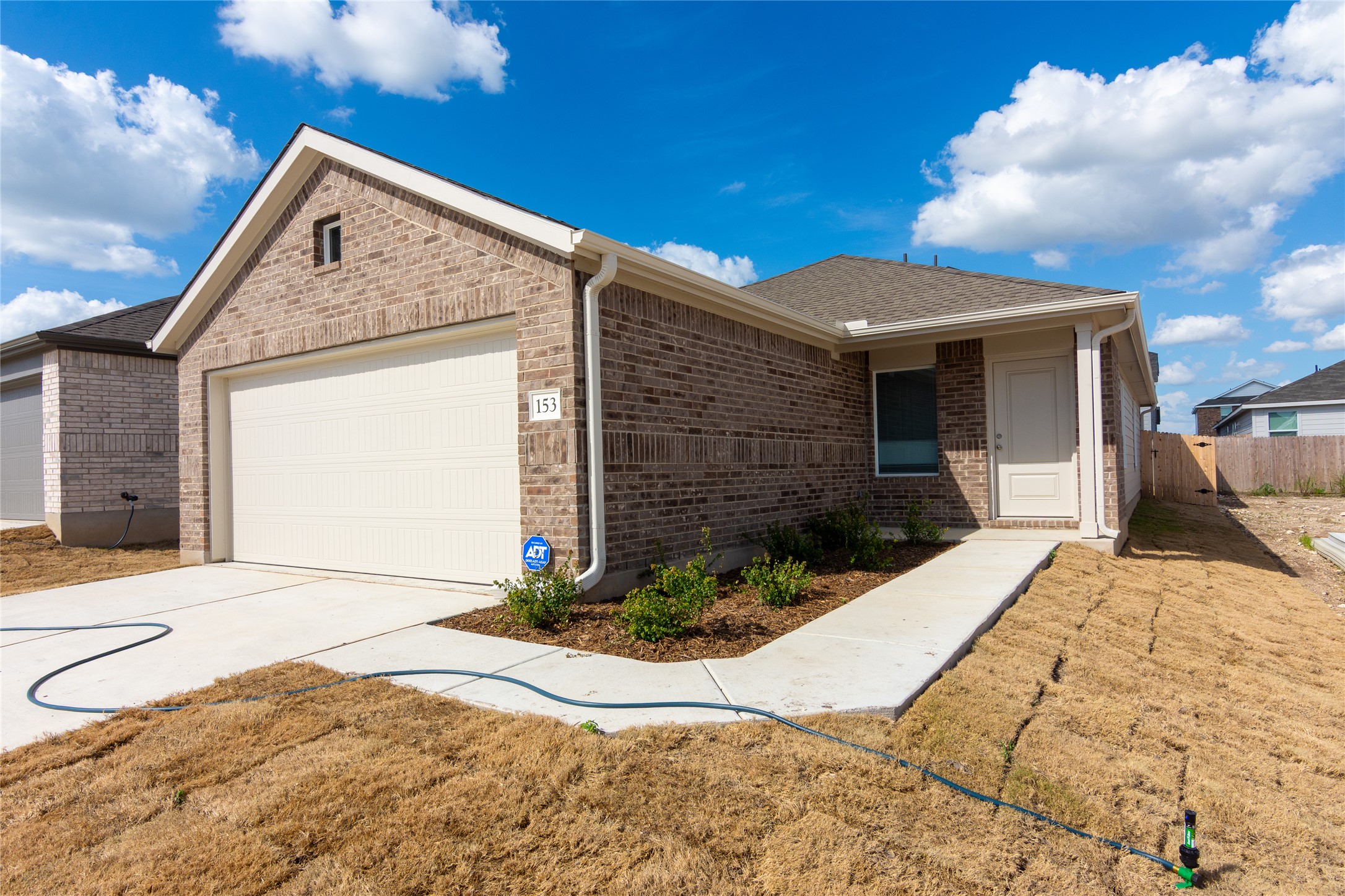 153 Star Packer Lane Jarrell, TX 76537 - Photo 2 of 30 A well-maintained facade with brick construction and an attached garage provides inviting curb appeal.