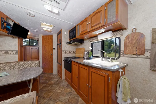 a kitchen with stainless steel appliances granite countertop a sink and a refrigerator