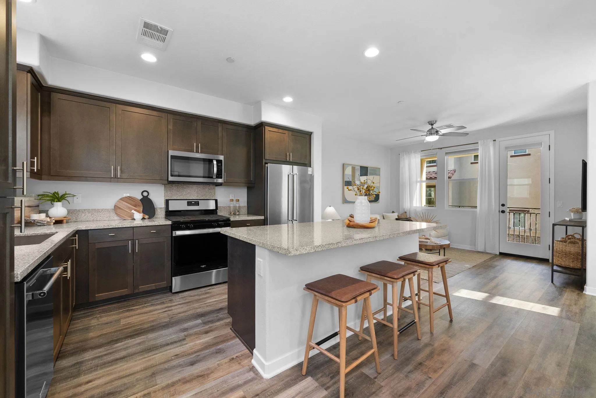 4229 Mission Ranch Way Oceanside, CA 92057 - Photo 4 of 26 a kitchen with kitchen island granite countertop wooden floors and stainless steel appliances