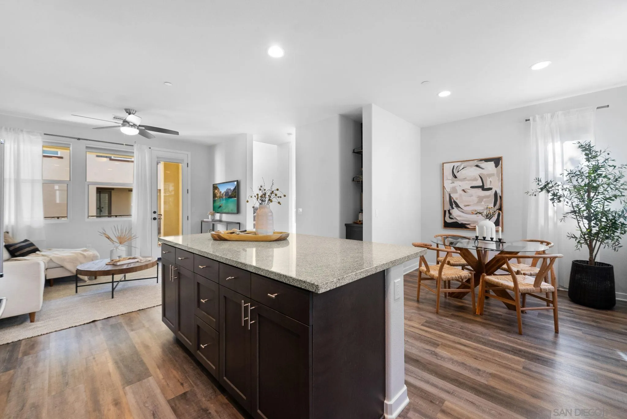4229 Mission Ranch Way Oceanside, CA 92057 - Photo 6 of 26 a large living room with stainless steel appliances granite countertop furniture a couch wooden floor and a rug