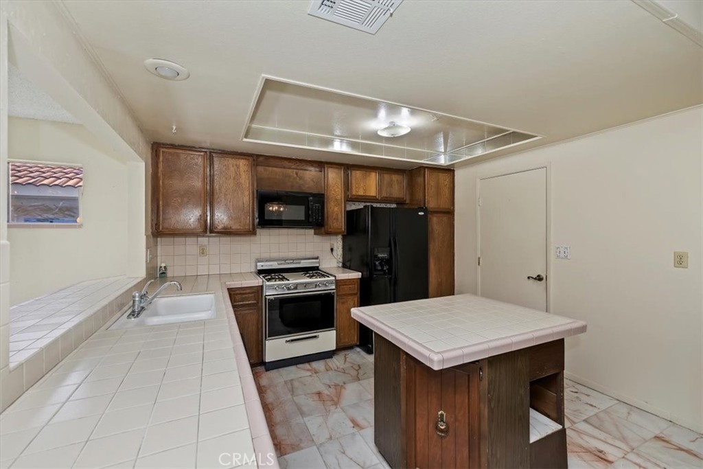 1825 Flame Tree Way Hemet, CA 92545 - Photo 13 of 23 a kitchen with a stove a refrigerator and a sink