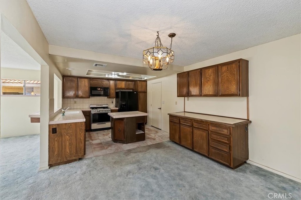 1825 Flame Tree Way Hemet, CA 92545 - Photo 10 of 23 a kitchen with stainless steel appliances granite countertop a sink dishwasher stove and refrigerator with wooden cabinets