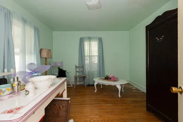 a view of a room with wooden floor table and chairs