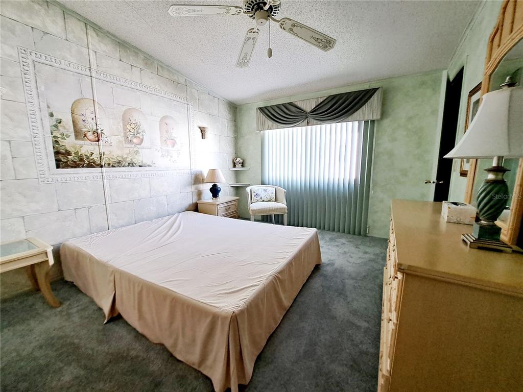 116 Maple Leaf Drive Palm Harbor, FL 34684 - Photo 18 of 38 a bed room with a bed and a chandelier
