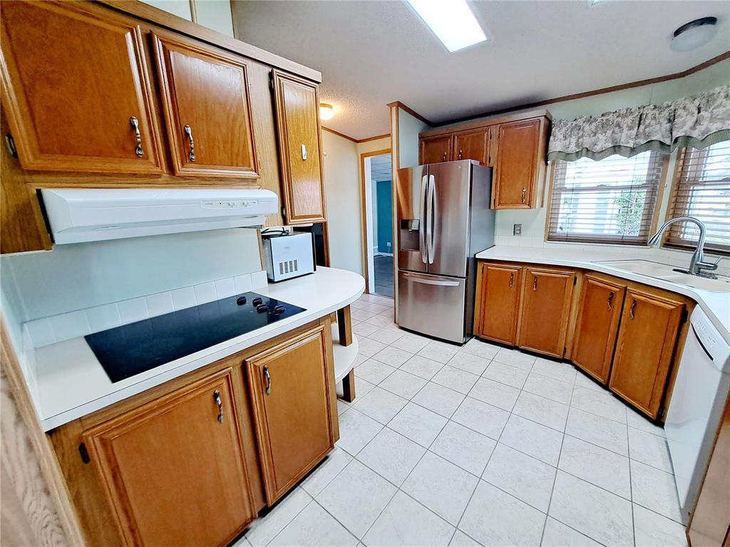 116 Maple Leaf Drive Palm Harbor, FL 34684 - Photo 7 of 38 a kitchen with stainless steel appliances a refrigerator and a sink