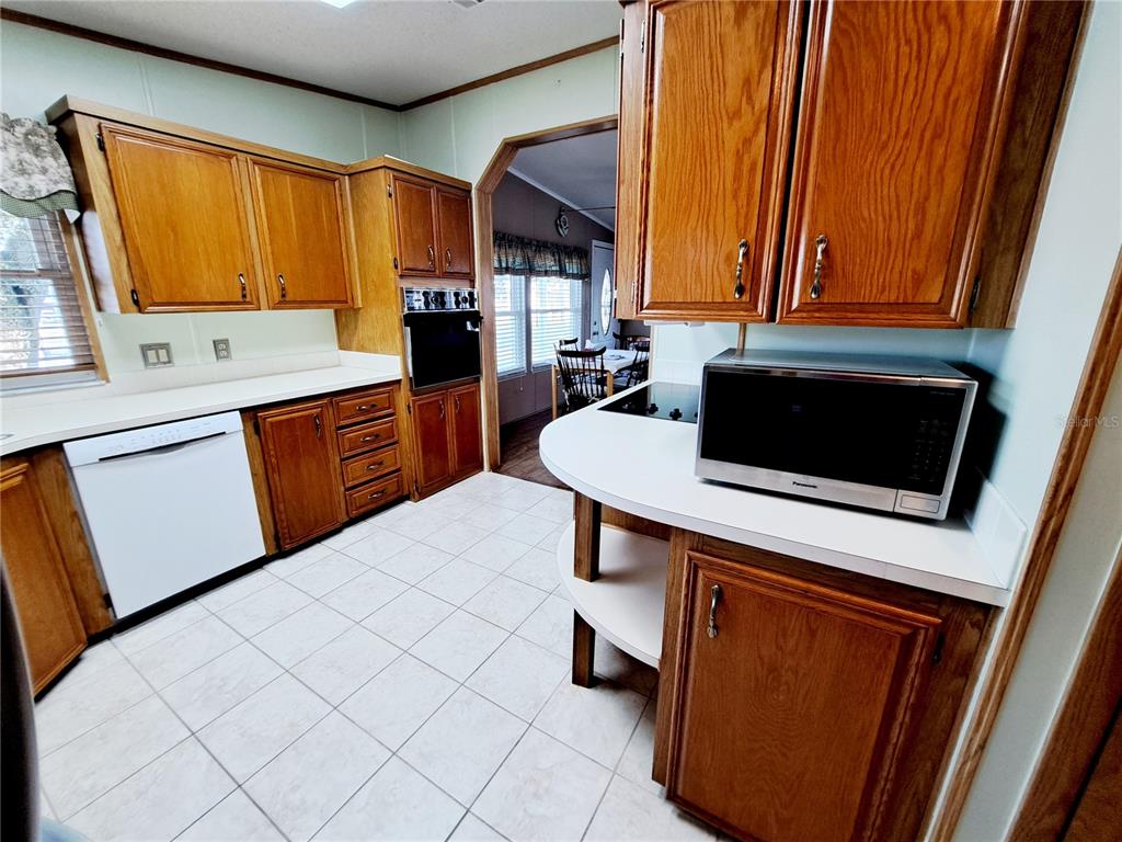 116 Maple Leaf Drive Palm Harbor, FL 34684 - Photo 9 of 38 a kitchen with stainless steel appliances a stove a sink and a refrigerator