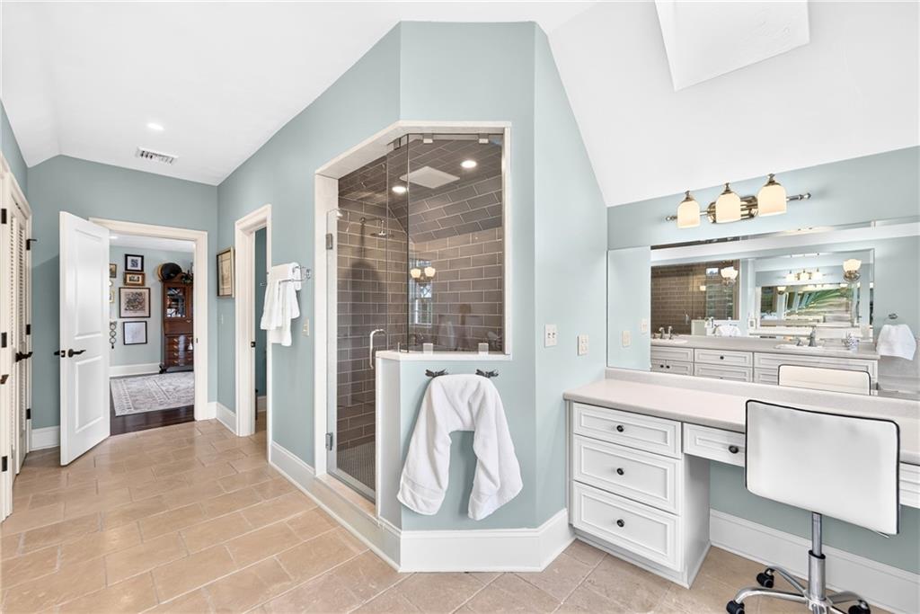 486 Settler Road Ligonier, PA 15658 - Photo 30 of 49 Dressing Table, with a skylight above, Shower w/Subway Tiles, multiple shower-heads, and bench.