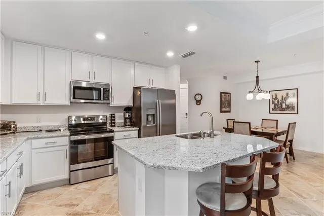 a kitchen with granite countertop kitchen island cabinets and stainless steel appliances