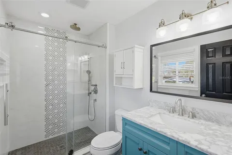 a bathroom with a granite countertop sink toilet a mirror a shower and a bathtub