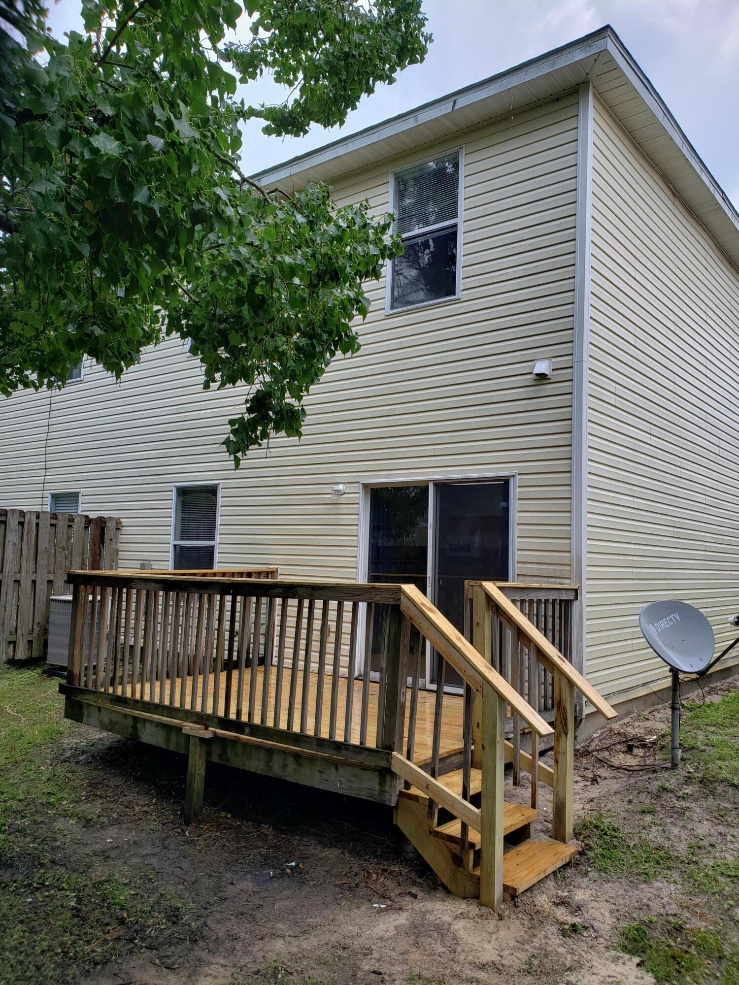 2127 Tom Street Navarre, FL 32566 - Photo 14 of 14 a view of a house with a yard and a deck
