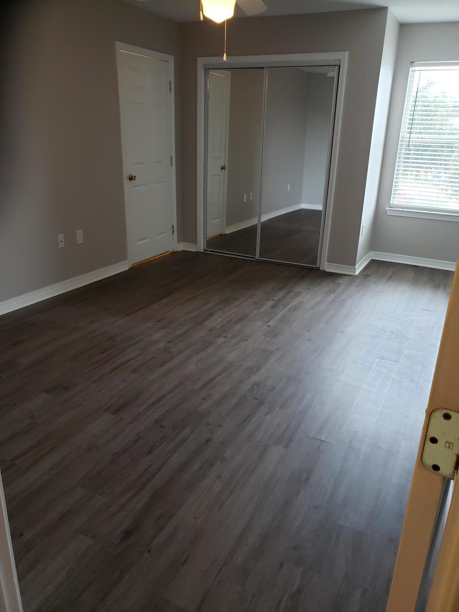 2127 Tom Street Navarre, FL 32566 - Photo 2 of 14 an empty room with wooden floor cabinet and door
