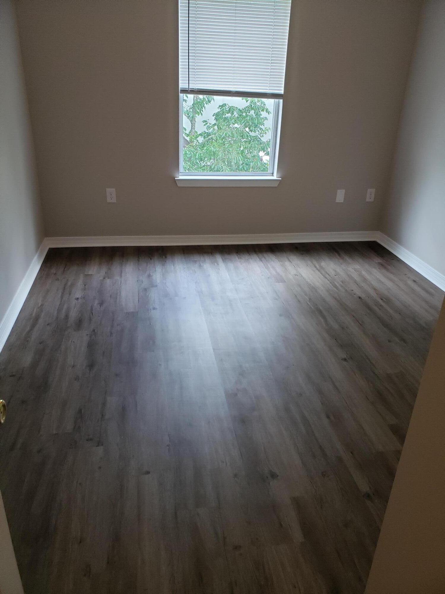 2127 Tom Street Navarre, FL 32566 - Photo 3 of 14 an empty room with wooden floor and windows