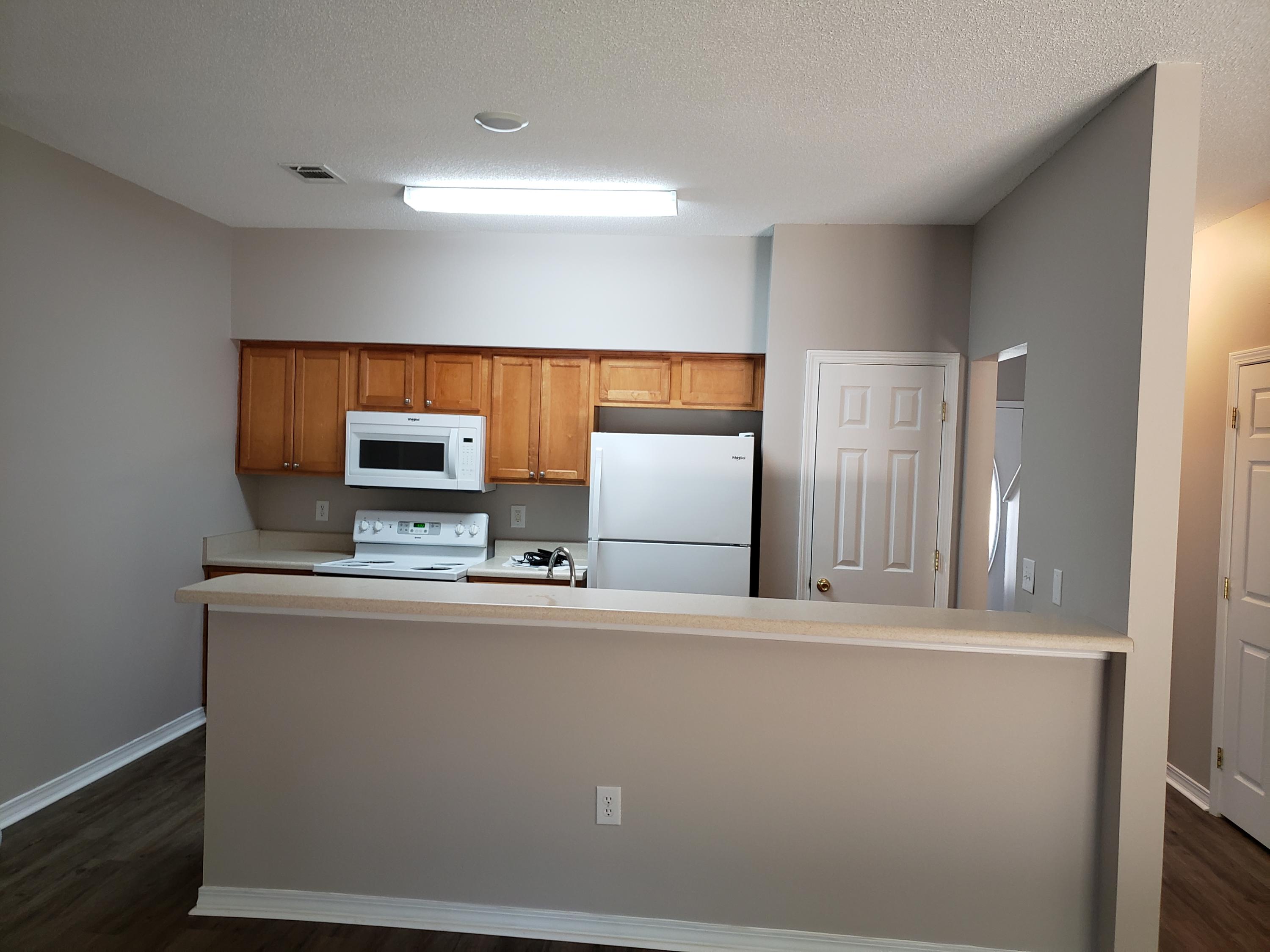 2127 Tom Street Navarre, FL 32566 - Photo 7 of 14 a view of a kitchen with stainless steel appliances wooden floor