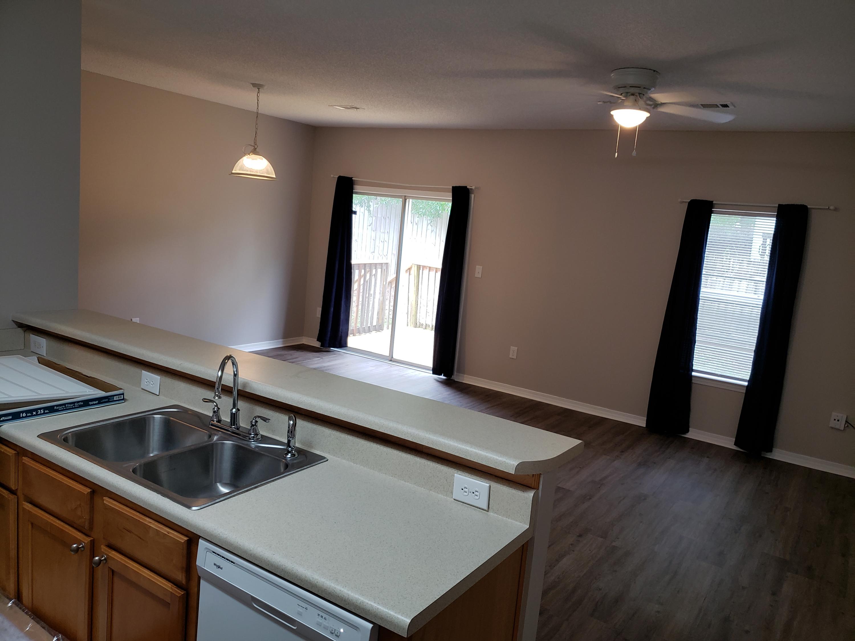2127 Tom Street Navarre, FL 32566 - Photo 8 of 14 a kitchen with a sink a refrigerator and wooden floor