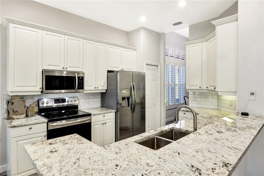 3376 Sandpiper Way Naples, FL 34109 - Photo 10 of 50 Sleek White Quartz Countertops and Modern Cabinetry