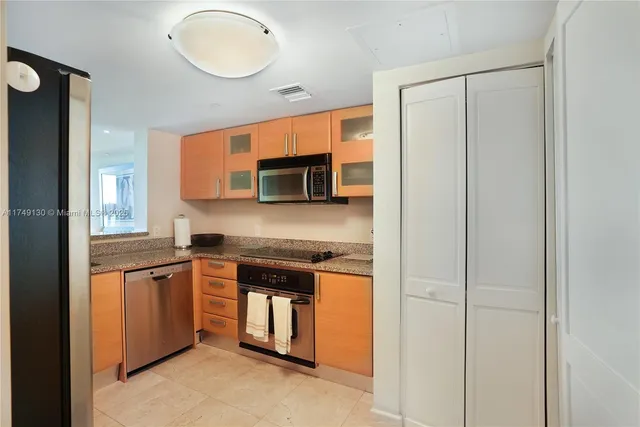 a kitchen with stainless steel appliances granite countertop a stove a sink and a microwave
