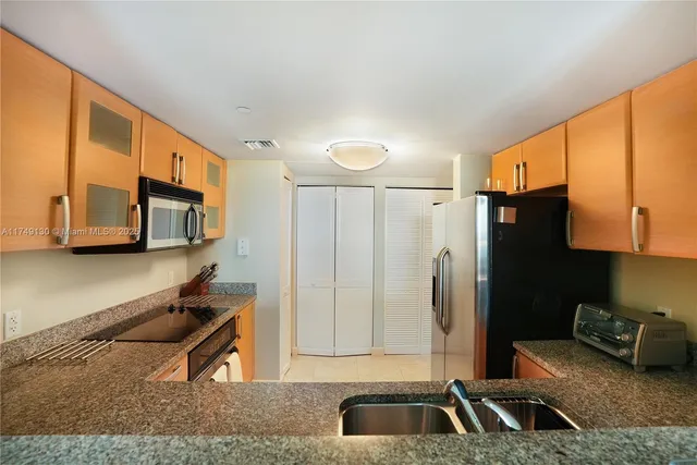 a kitchen with stainless steel appliances granite countertop a refrigerator and a sink