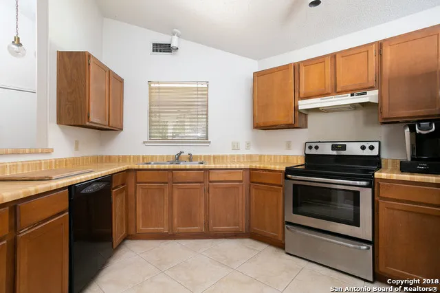 a kitchen with stainless steel appliances granite countertop a stove sink and cabinets
