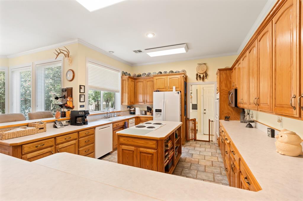 1264 Overlook Drive Whitney, TX 76692 - Photo 28 of 39 a large kitchen with stainless steel appliances a stove a sink dishwasher and white cabinets with wooden floor