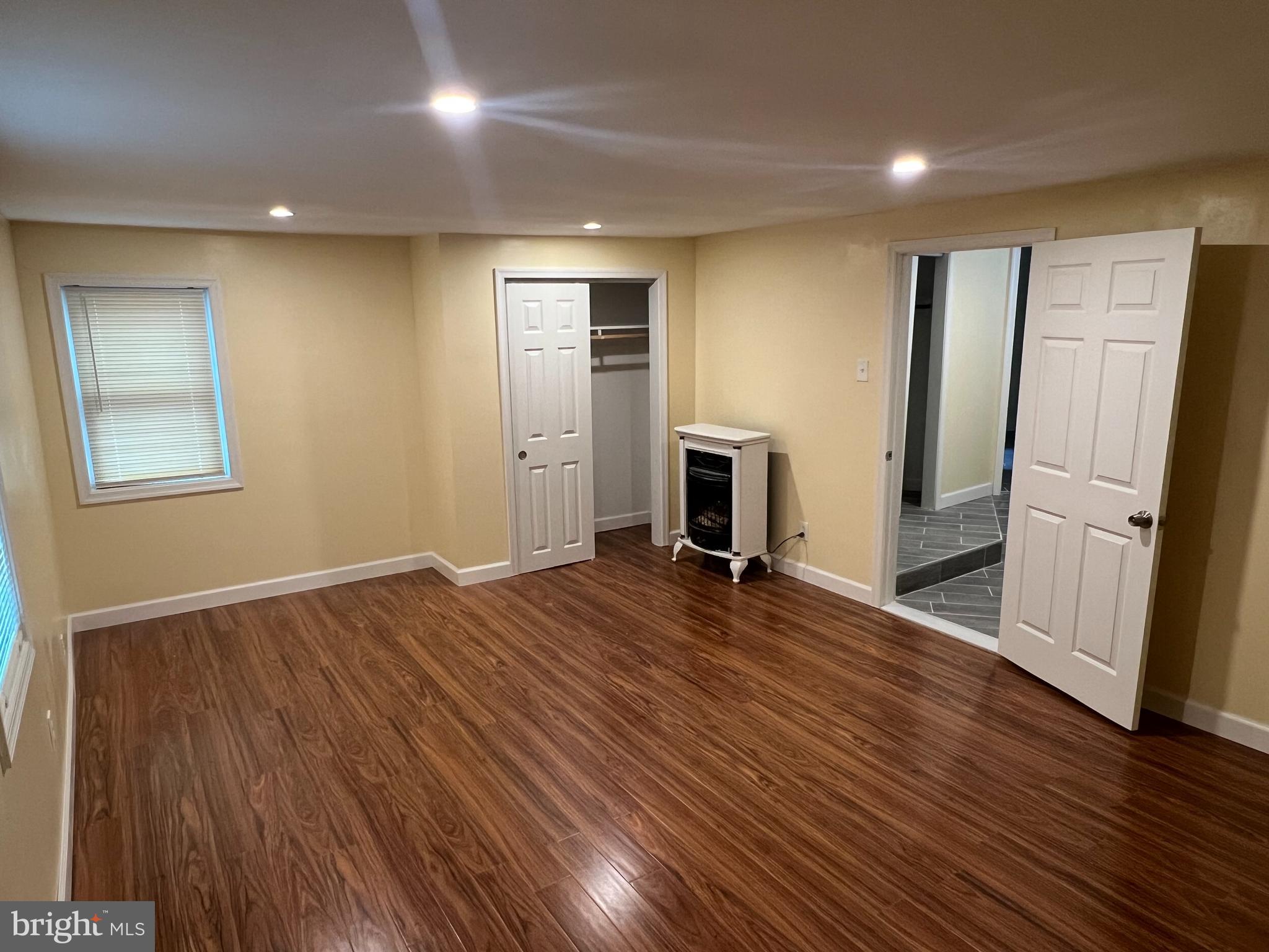 229 Chews Landing Road Lindenwold, NJ 08021 - Photo 3 of 11 an empty room with wooden floor and a fireplace