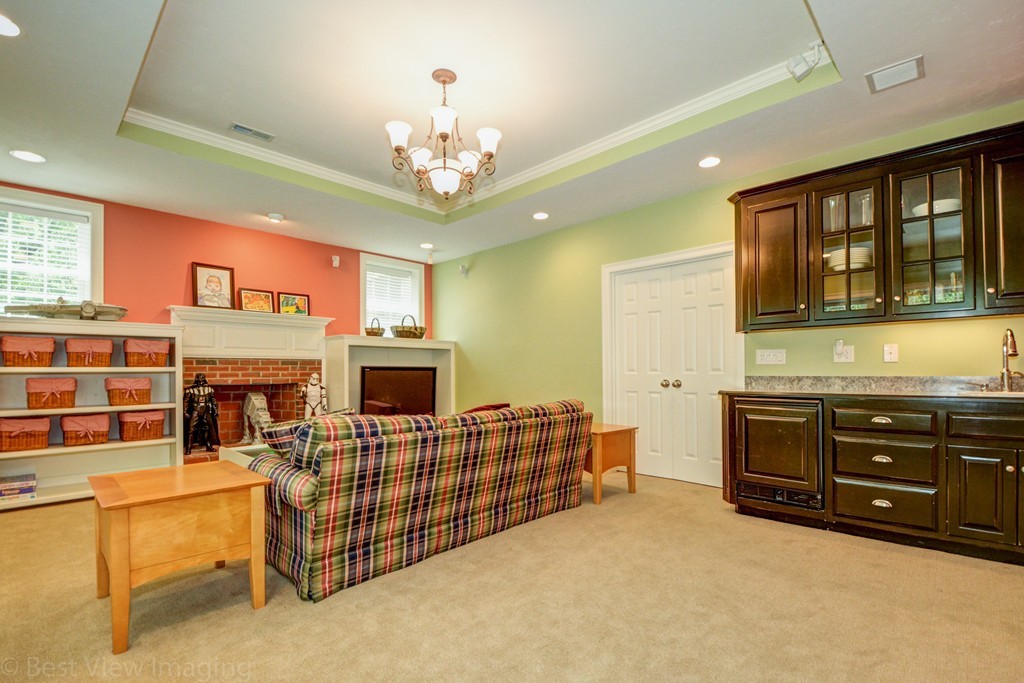 29 Prospect Street Upton, MA 01568 - Photo 28 of 30 a living room with furniture a fireplace and a chandelier
