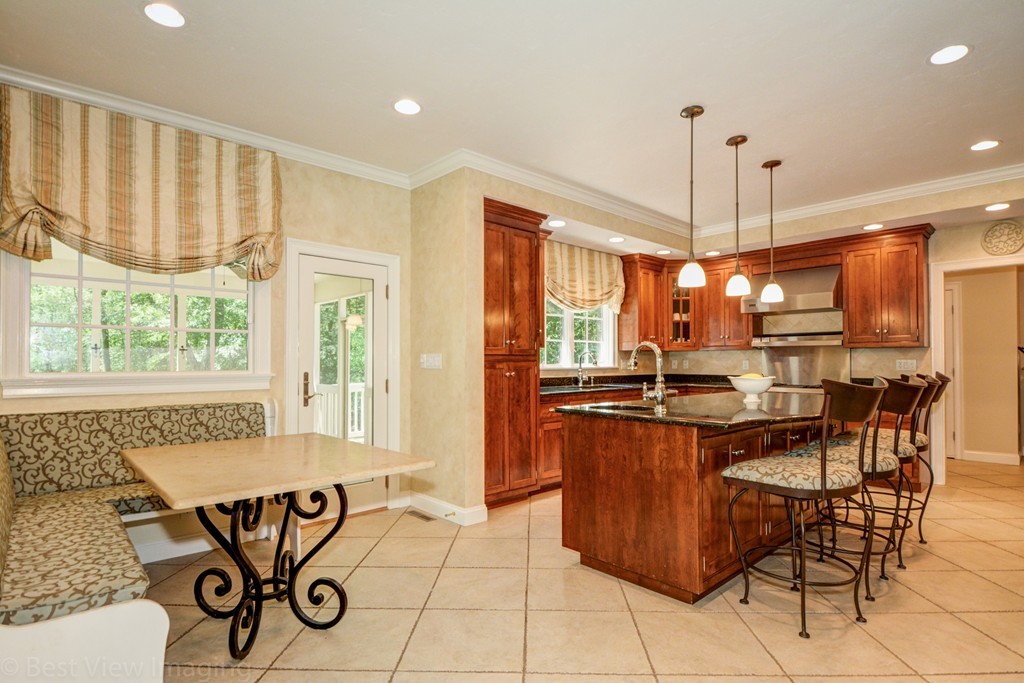 29 Prospect Street Upton, MA 01568 - Photo 9 of 30 a kitchen with stainless steel appliances granite countertop a stove a sink a dining table and chairs with wooden floor