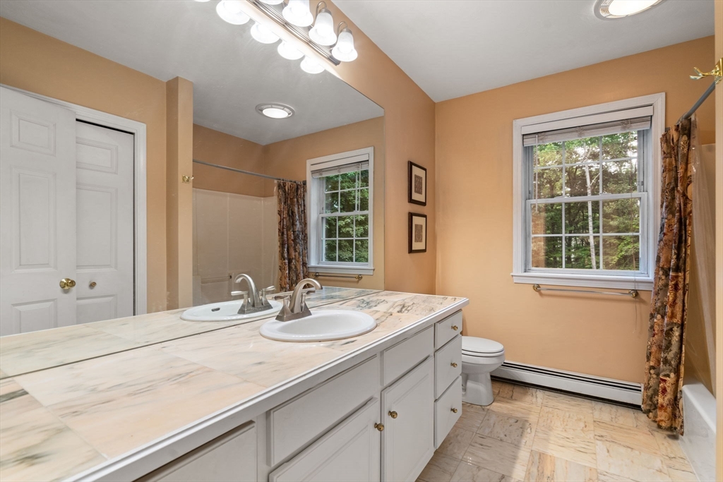 60 Easter Brook Road Lunenburg, MA 01462 - Photo 19 of 37 a bathroom with a double vanity sink a large mirror and a bathtub