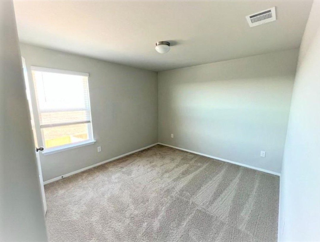 2771 Winding Creek Road Kyle, TX 78640 - Photo 14 of 24 An inviting sleeping space with ample natural light, ready for personalized touches.