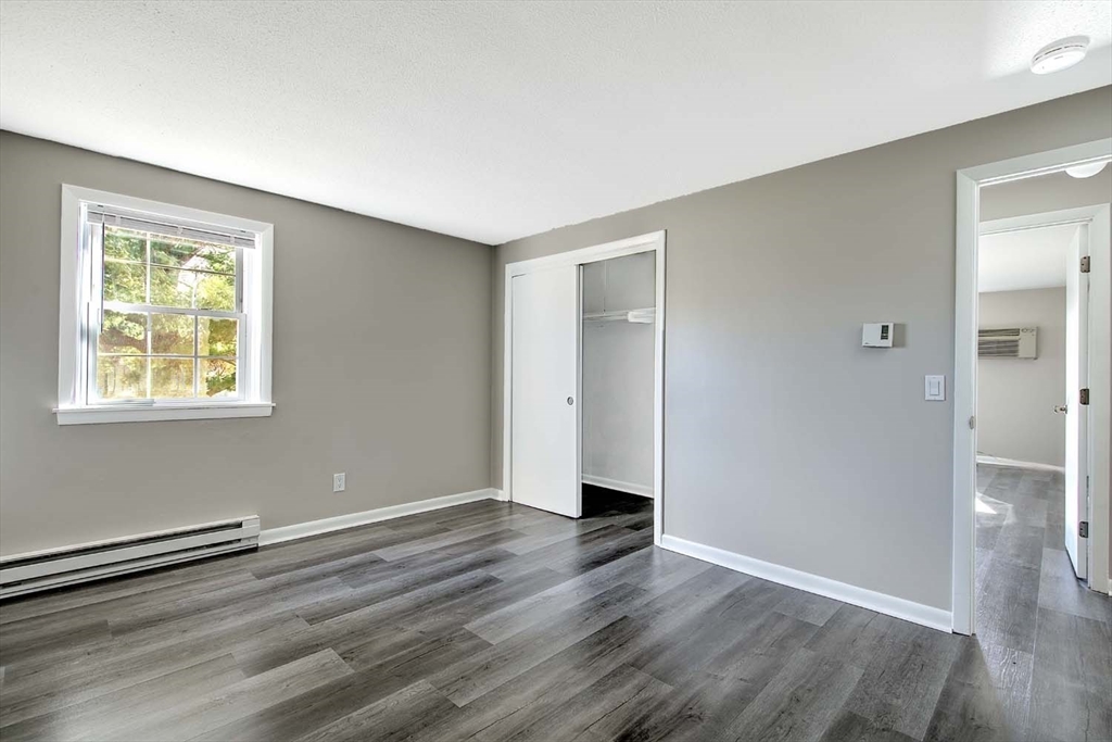 91 Pleasant Street, Unit A6 Medfield, MA 02052 - Photo 15 of 29 a view of an empty room with wooden floor and a window