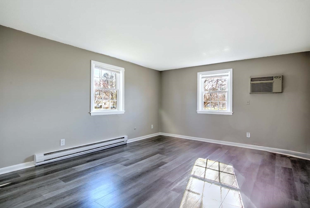 91 Pleasant Street, Unit A6 Medfield, MA 02052 - Photo 17 of 29 an empty room with wooden floor and windows