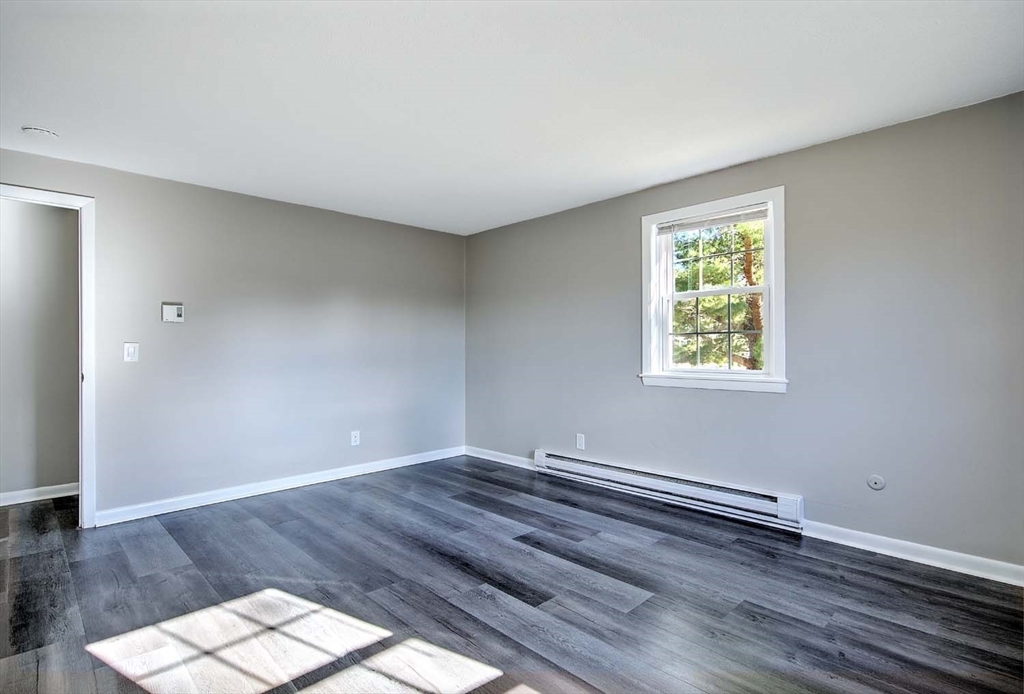 91 Pleasant Street, Unit A6 Medfield, MA 02052 - Photo 20 of 29 an empty room with wooden floor and windows