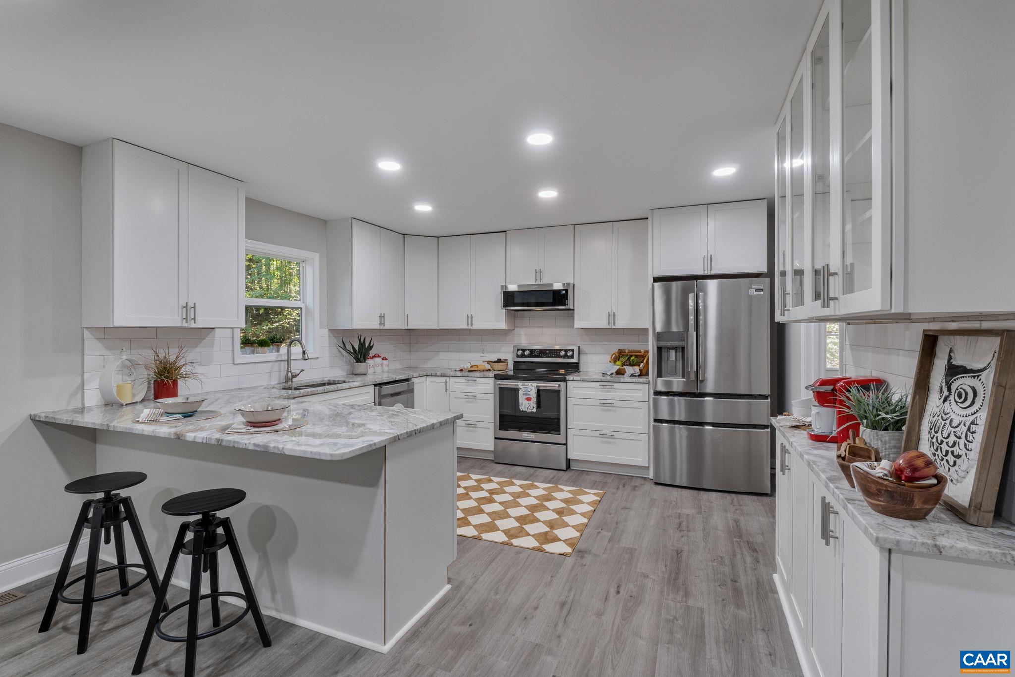 612 Oneals Road Pratts, VA 22731 - Photo 5 of 68 a kitchen with stainless steel appliances kitchen island granite countertop a refrigerator a stove a sink dishwasher and white cabinets with wooden floor