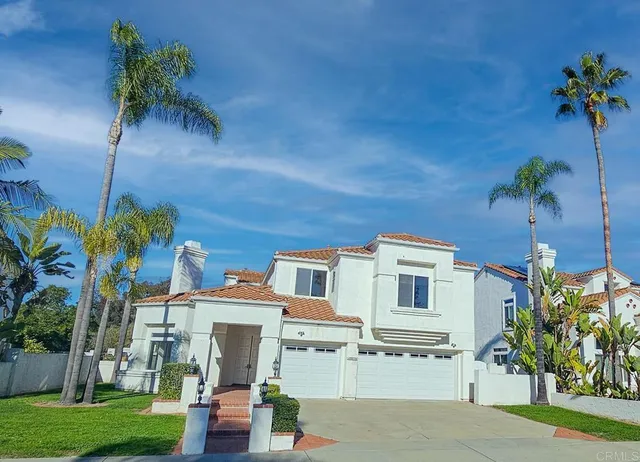 a view of a building with a yard and a palm tree