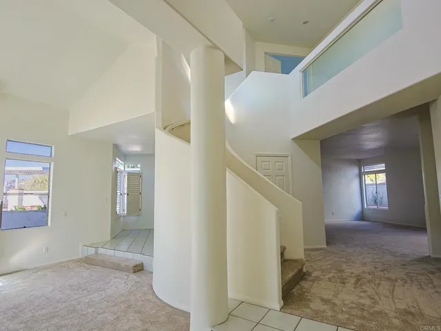 a view of a hallway with wooden floor and a living room