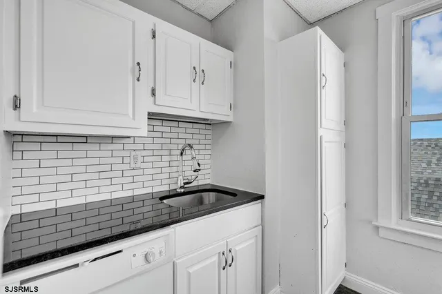 a kitchen with white cabinets and a sink