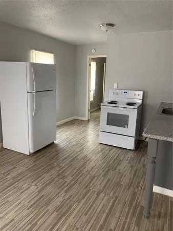 a view of kitchen with stainless steel appliances granite countertop a stove a refrigerator and a microwave