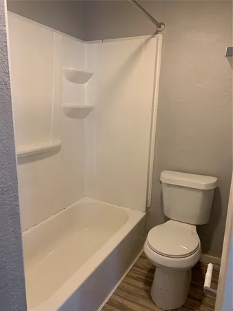 a white toilet sitting next to a bath tub