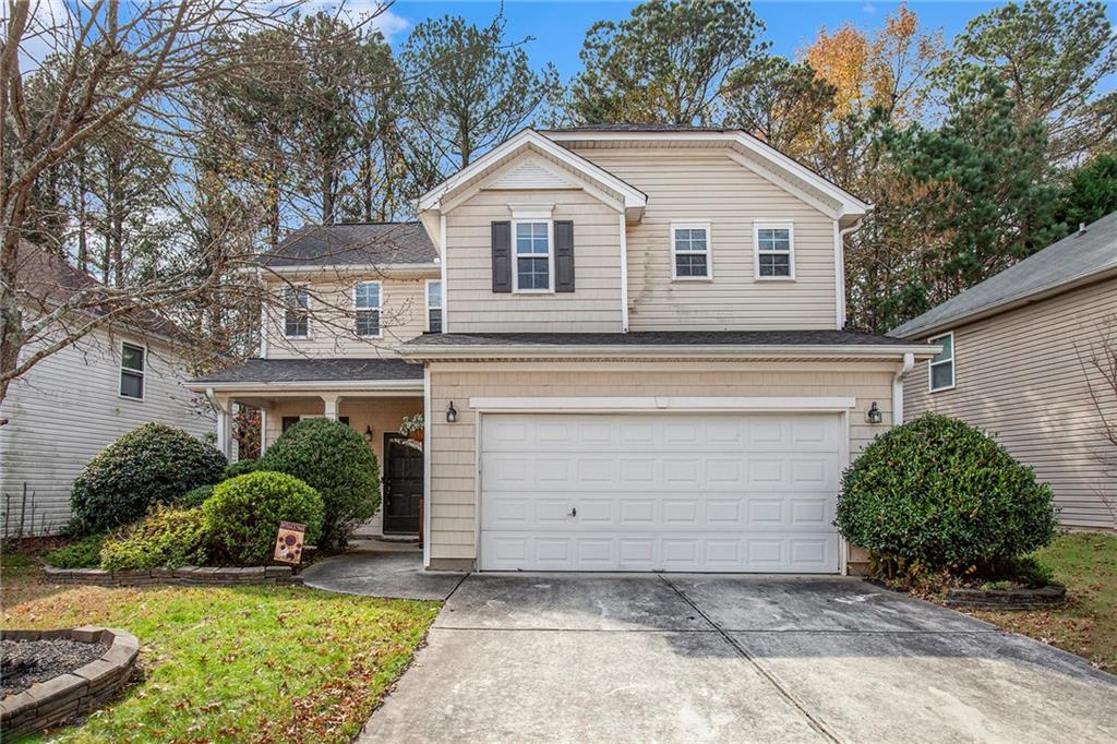 a view of a white house with large windows and a large tree