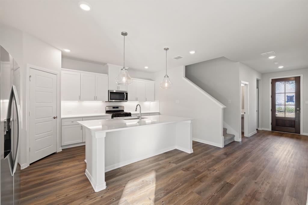 1840 Rosedale Avenue Van Alstyne, TX 75495 - Photo 3 of 26 a kitchen with stainless steel appliances kitchen island granite countertop a stove a refrigerator a sink and a oven with wooden floor