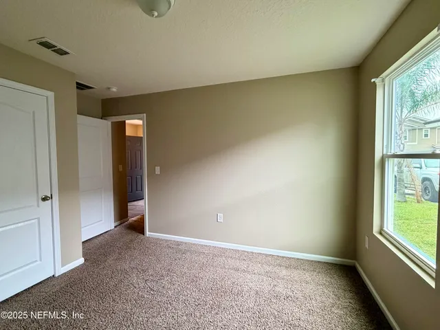 an empty room with windows and closet