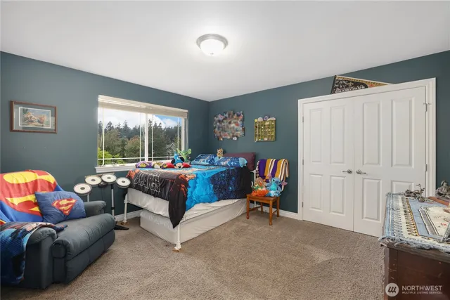 a bedroom with a bed and large windows