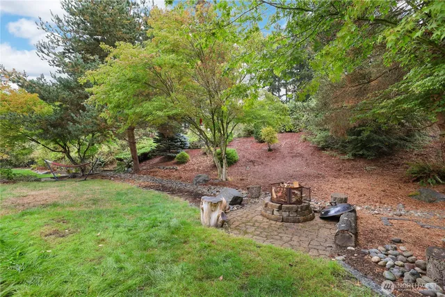 a front view of a house with garden and trees