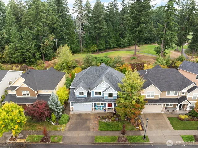 an aerial view of a residential houses with yard