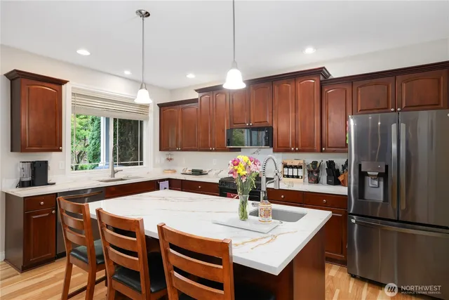 a kitchen with kitchen island granite countertop a sink a center island and cabinets